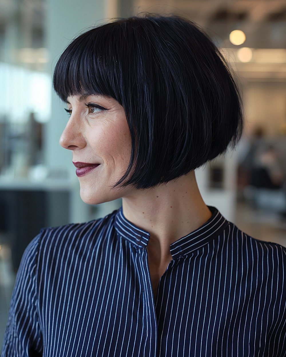 Chin-length French bob with blunt fringe on sleek black hair for a sharp, bold finish