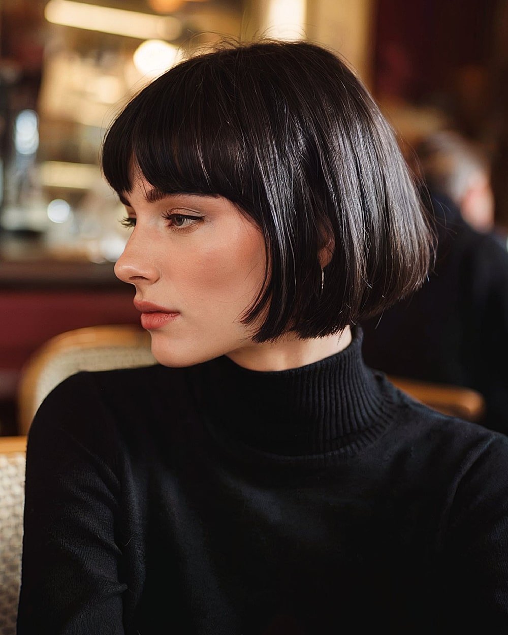 Classic Parisian French bob with blunt bangs and sleek black hair for a timeless finish