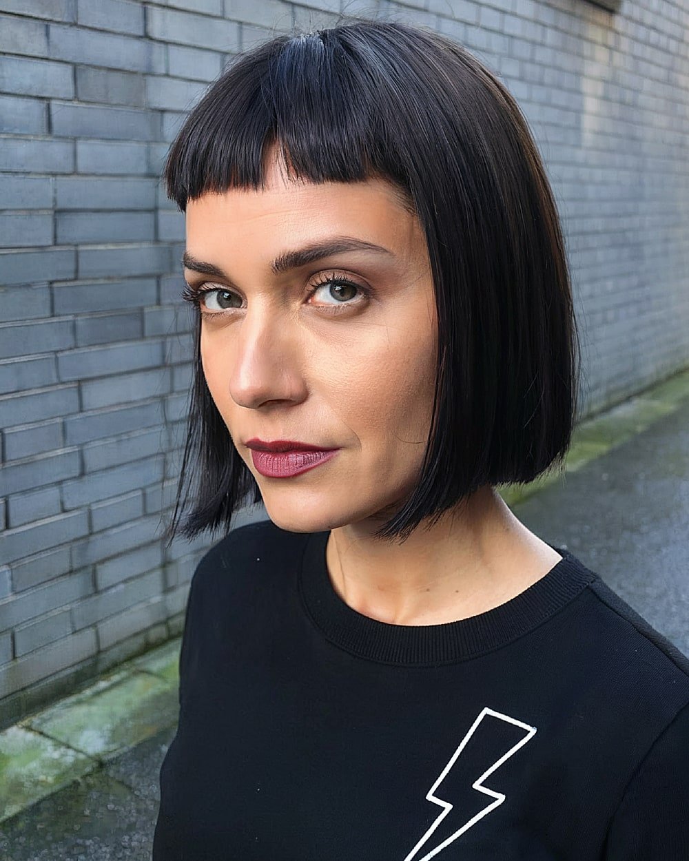 French bob with blunt micro bangs on sleek black hair for an edgy, modern look