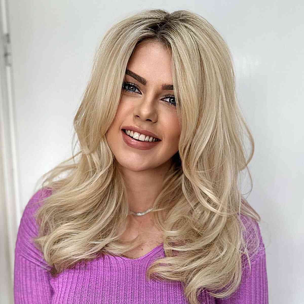 Stunning Straight Layered Hair for women with mid-length blonde hair and curled ends